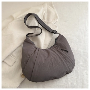 Deep grey crescent dumpling bag in textured nylon with adjustable black strap and zipper