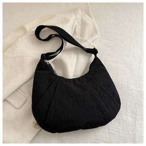 Detail view of the black crescent moon dumpling bag with pleated nylon fabric and strap