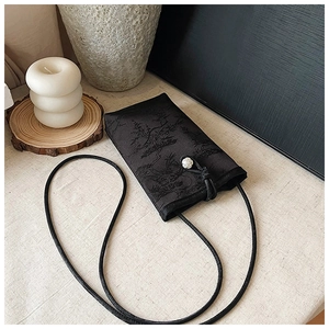 Détail de la pochette téléphone chinoise brodée avec texture soie et nœud rose