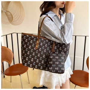 Detailed view of a printed tote bag set featuring palm leaf patterns and small pouch