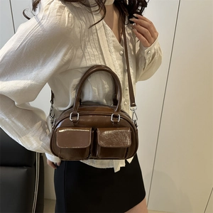 Brown patent leather mini pillow bag with front utility pockets and adjustable strap