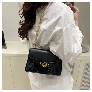Détail du sac bandoulière noir avec boucle M dorée et motif floral en relief élégant