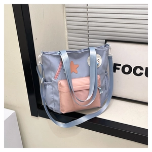 Detail der Colorblock-Einkaufstasche mit orangem Stern-Patch und elastischer Seitentasche