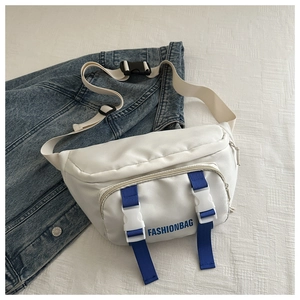 Détail du sac bandoulière en nylon blanc avec sangles bleues et boucle sur fond de jean