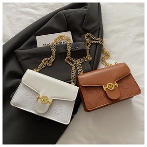 Détail de motifs floraux et carpes koi gaufrés sur sacs vintage avec boucle en métal M