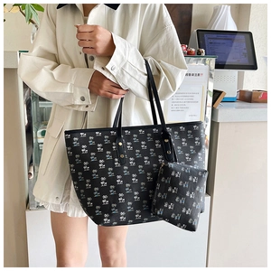 Detail of black tote bag with palm tree print and matching mini pouch for daily commuting