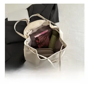 Interior capacity show of cream white drawstring backpack with umbrella and notebook