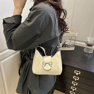 Elegant cream shoulder bag with silver bow buckle and metal chain strap for women