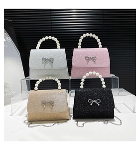 Detail of four sequined mini bags in silver pink gold black with pearl handles