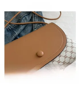 Dettaglio della borsa a sella vintage con motivo monogramma retrò e patta in pelle