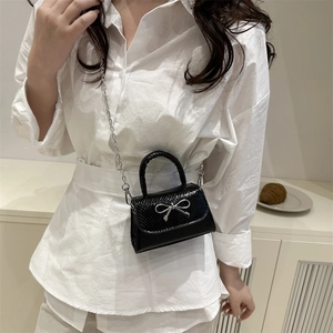 Chic black crocodile embossed mini crossbody bag with silver bow detail and chain strap