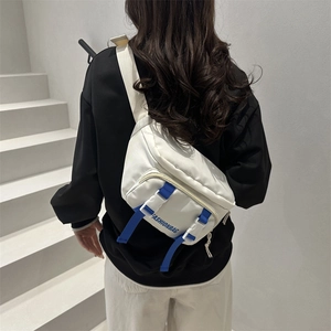 Sac de poitrine minimaliste en nylon blanc avec sangles bleues porté en style urbain