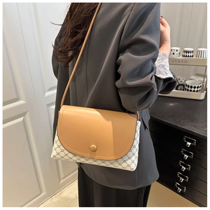 Dettaglio borsa a tracolla da donna con patta color terra e motivo geometrico vintage