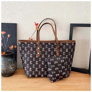 Close-up of brown two-piece tote bag set with tropical coconut tree print and gold studs