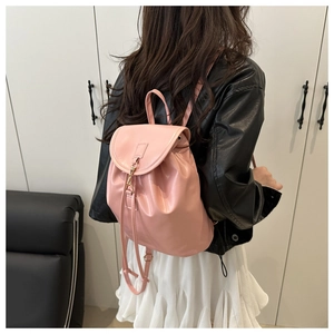 Close-up of pink PU leather backpack with gold metal clasp and drawstring closure