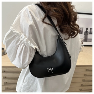 Detail of black crescent hobo bag with silver metal bow and slim shoulder strap