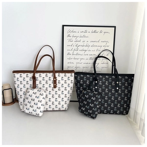 Detail of printed tote bag set featuring tropical palm patterns in black and creamy white
