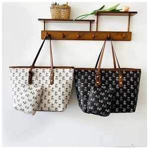 Detail of printed tote bag set with palm tree patterns and matching coin purses on hooks