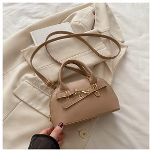 Detail of khaki leather shell bag with metal buckle on beige blazer background