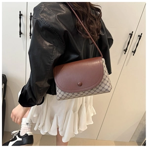 Dettaglio borsa a tracolla da donna con patta in pelle marrone e motivo monogramma retro
