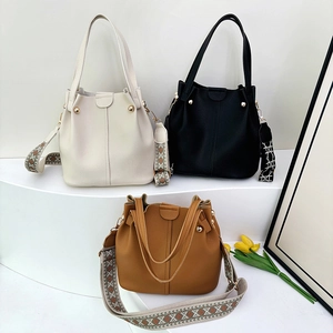 Minimalist large capacity bucket bag in white, black, and tan with vintage wide straps
