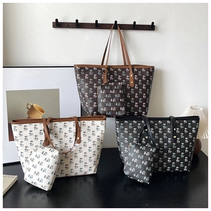 Detail of printed tote set showing large shoulder bag and matching pouch with rivet studs