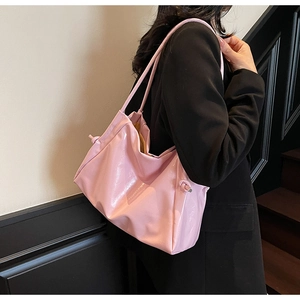 Vue latérale du grand sac cabas rose avec nœuds coulissants et finition en cuir verni