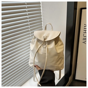 Detail of cream leather backpack with drawstring closure and golden metal hook buckle
