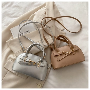 Detail of silver and khaki dome bags with belt strap decoration and metal hooks