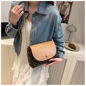 Dettaglio della borsa a tracolla vintage con patta in pelle crema e tracolla sottile