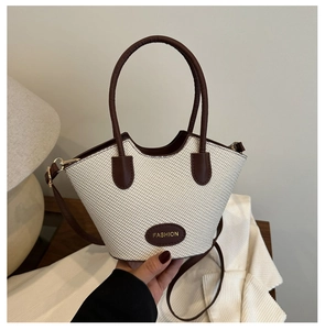 Détail de la texture tissée et de la bordure en cuir brun d'un sac seau vintage