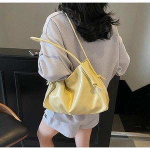 Détail du sac cabas en cuir verni jaune vif avec bandoulière à gros nœuds en corde