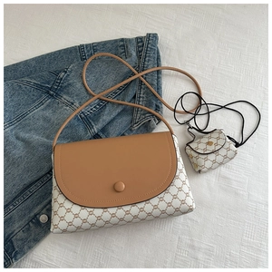 Dettaglio della borsa bicolore con motivi vintage e mini pochette coordinata
