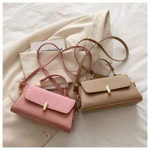 Detail of minimalist leather crossbody bags featuring elegant gold metal clasp and soft colors