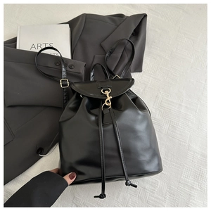 Detail shot of black PU leather backpack with gold metal hook and drawstring closure