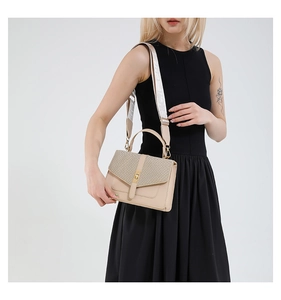 Détail du sac beige avec rabat à texture tissée et boucle dorée élégante