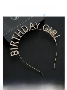 Gros plan du serre-tête doré Birthday Girl avec strass sur un coffret noir élégant