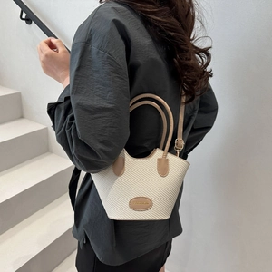 Sac seau tissé beige minimaliste avec poignées en cuir et bandoulière réglable