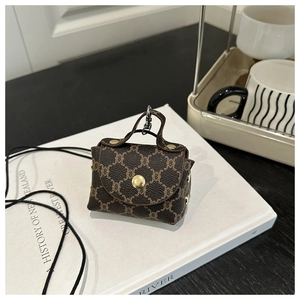 Dettaglio mini pochette vintage con chiusura dorata sopra un libro bianco