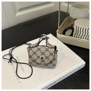 Dettaglio ravvicinato di una mini borsa a tracolla retrò monogram con finiture dorate