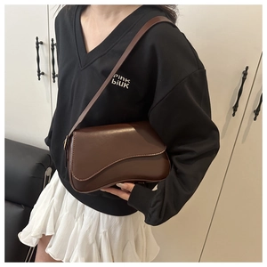 Detail view of smooth coffee brown crescent leather shoulder bag with flap closure