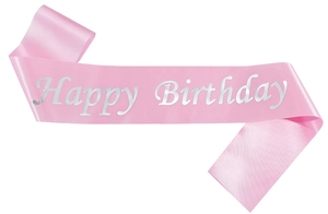 Detailed macro shot of pink satin fabric texture with silver glitter Happy Birthday text