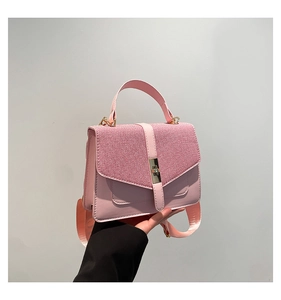 Détail du sac bandoulière rose avec rabat bi-matière et fermoir rotatif en métal