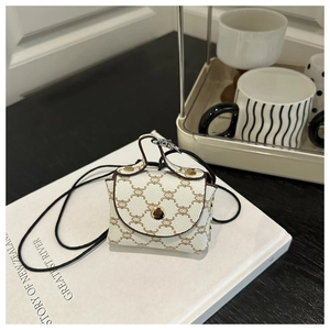 Dettaglio di una mini borsa a tracolla avorio con monogramma e chiusura dorata