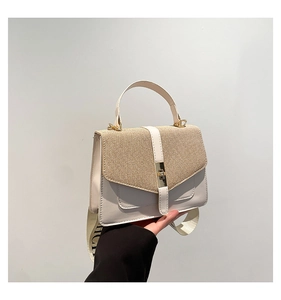 Détail du sac blanc avec rabat en paille et large bandoulière logo de style guitare