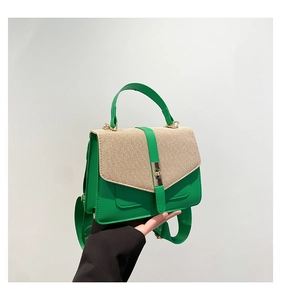Détail du sac en cuir vert avec texture tissée beige et large bandoulière