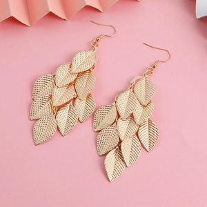 Bohemian gold leaf tassel drop earrings with layered vein texture on pink background