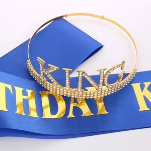 Close-up of golden rhinestone KING crown and blue satin BIRTHDAY KING party sash