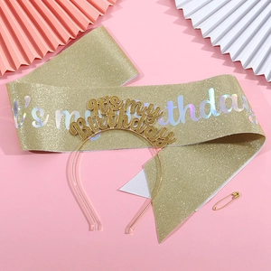 Close-up of golden glitter birthday sash and matching headband with holographic text