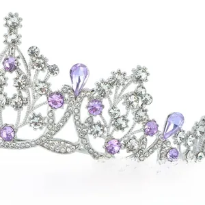 Close-up of silver tiara with purple and clear crystals featuring intricate filigree details